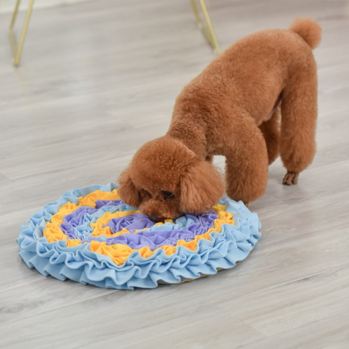 a long hair dog is using the snuffle mat 